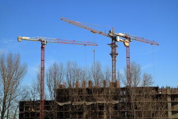 Tower cranes are working on the construction of a new house. Lifting crane.