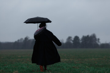 Girl with an umbrella in the field.