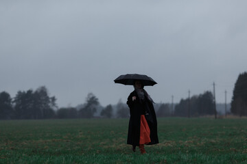 Girl with an umbrella in the field.