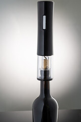 open a wine bottle with an electric corkscrew automatically