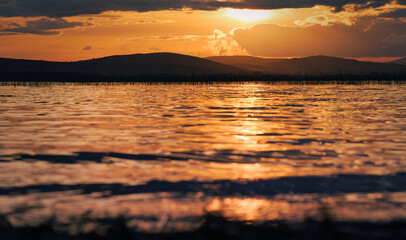 Beautiful evening orange sunset scenery with mountains in the background at Corrib lake in Galway, Ireland 