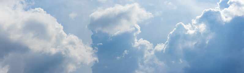 Cumulus light and dark clouds in the sky in sunny weather