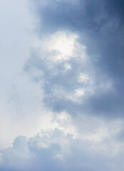 The gloomy sky is covered with clouds of different shapes and colors