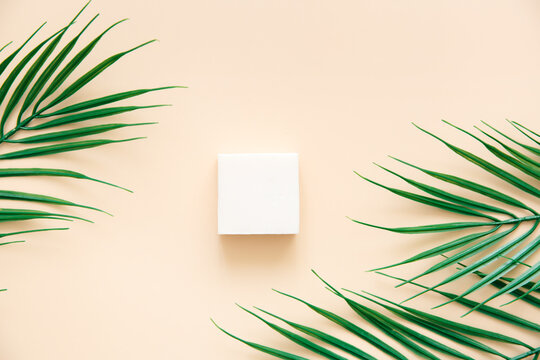  Natural handmade soap and palm leaves on a beige background, top view. Skin care and beauty concept. Mockup for design. © Katerina Bond