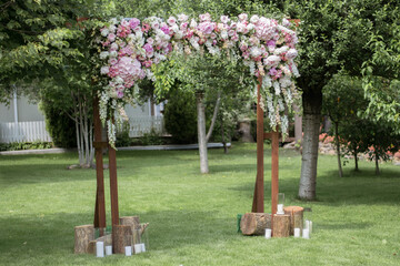 Obraz premium Wedding ceremony. Very beautiful and stylish wedding arch, decorated with various fresh flowers, standing in the garden.