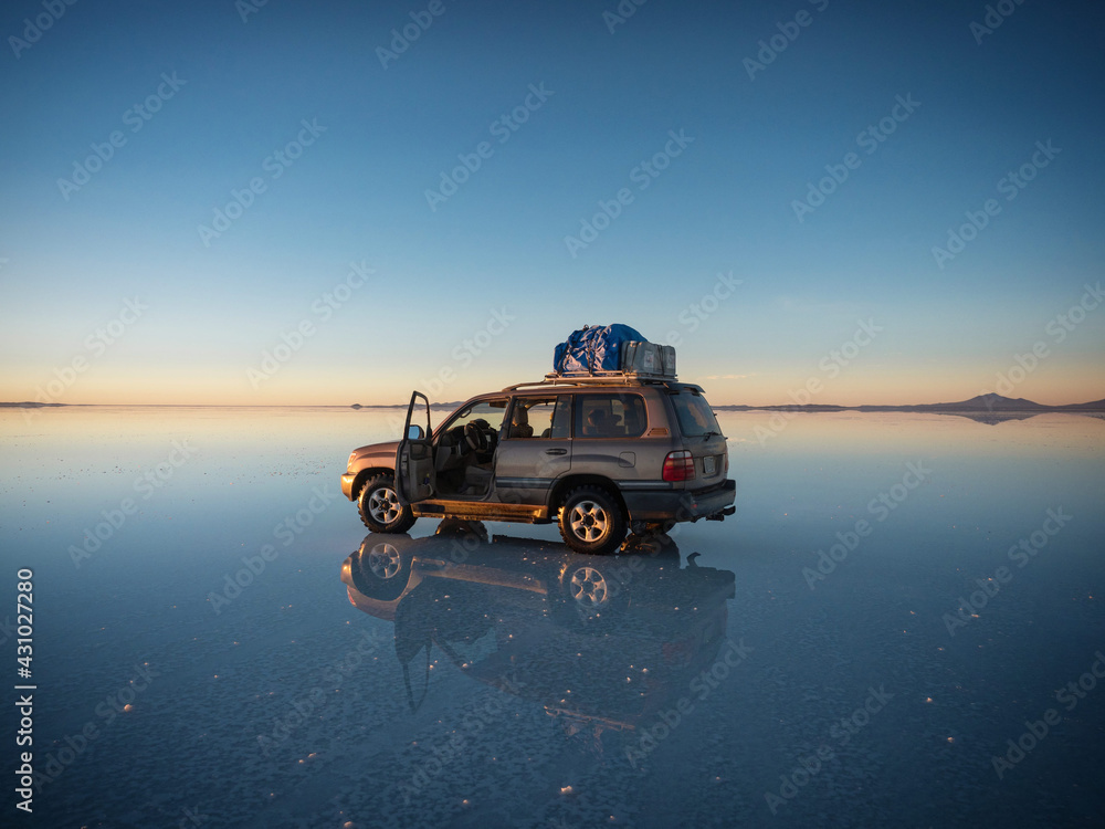 Wall mural offroad car suv jeep of tour group on salar de uyuni salt flat lake in bolivia andes mountains sunri