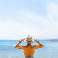 Fototapeta na wymiar Happy woman enjoying beach relaxing joyful in summer by tropical blue water.