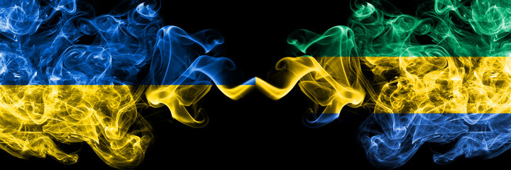 Ukraine, Ukrainian vs Gabon, Gabonese, Gabonian smoky mystic flags placed side by side. Thick colored silky abstract smokes flags.