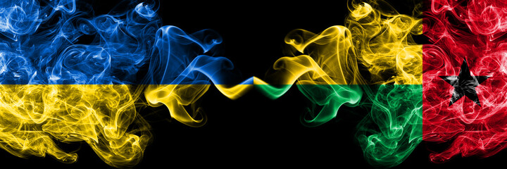 Ukraine, Ukrainian vs Guinea Bissau smoky mystic flags placed side by side. Thick colored silky abstract smokes flags.