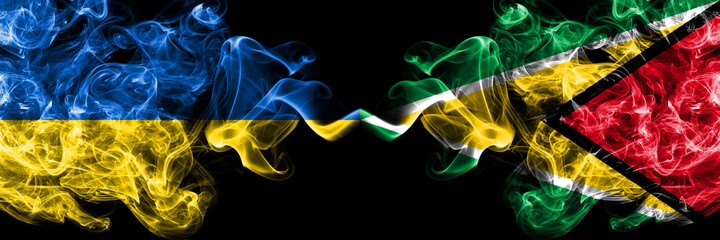 Ukraine, Ukrainian vs Guyana smoky mystic flags placed side by side. Thick colored silky abstract smokes flags.