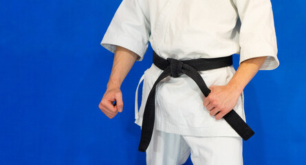 Hombre con kimono blanco y cinturón negro  con fondo azul