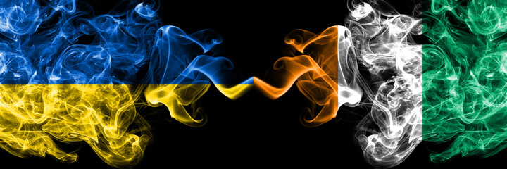 Ukraine, Ukrainian vs Ivory Coast smoky mystic flags placed side by side. Thick colored silky abstract smokes flags.
