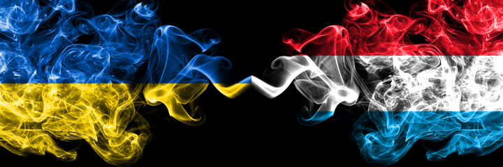 Ukraine, Ukrainian vs Luxembourg smoky mystic flags placed side by side. Thick colored silky abstract smokes flags.
