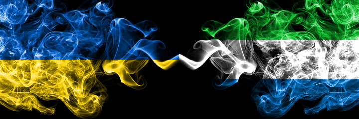 Ukraine, Ukrainian vs Sierra Leone smoky mystic flags placed side by side. Thick colored silky abstract smokes flags.