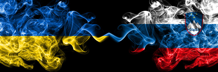 Ukraine, Ukrainian vs Slovenia, Slovenian smoky mystic flags placed side by side. Thick colored silky abstract smokes flags.