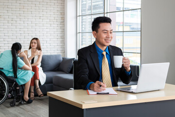 Businessman sitting on workplace drinking coffee while working at his desk. Handsome businessman working on laptop in his workstation in office. Mature businessman working on laptop computer.