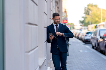 A businessman walking and checking the time