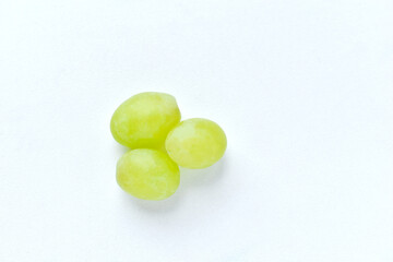 Three grapes close up on a white background