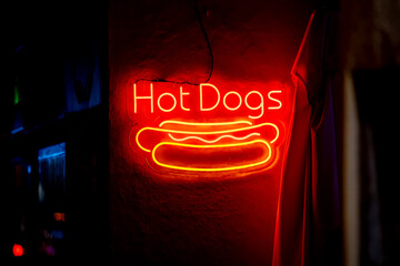 Illuminated sign for Hot Dogs on a street in the center of Madrid in Spain at night