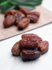 Fruits of date palm Phoenix dactylifera on white wood,Dried dates