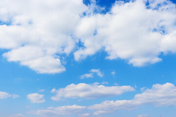 Naklejka na ściany i meble Blue sky with cumulus clouds. White clouds like cotton wool. Beautiful sky on a hot sunny day