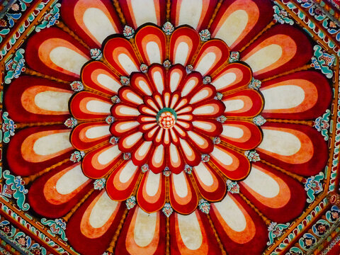 Red, white, and green pattern on the ceiling in an Indian temple