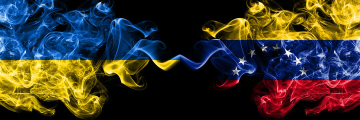 Ukraine, Ukrainian vs Venezuela smoky mystic flags placed side by side. Thick colored silky abstract smokes flags.