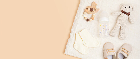 Gender neutral baby shoes and accessories over beige background.