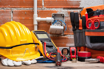 Tool bag, tools and work equipment for electrician technician on a wooden workbench. Construction industry. 