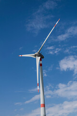 Wind turbine that stand out against the blue summer sky of the Tuscan countryside