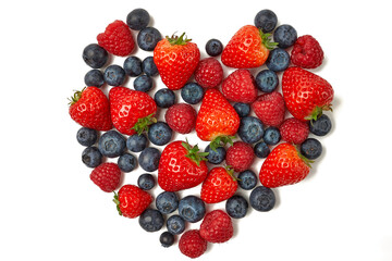 A heart from blueberries, strawberries and raspberries on a white background.