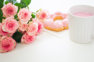 cup of pink drink and roses