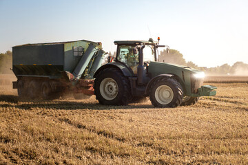 Tractor with a grain cart on an already harvested field