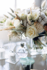 luxurious bouquet of fresh flowers stands on a glass table. White fresh roses as the basis of the wedding style. Blurred background and selected focus