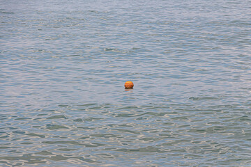Beautiful blue sea with an orange buoy