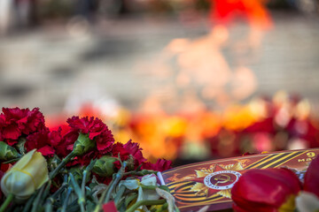 flowers at the memorial fire. the memory of the fallen soldiers in the military conflict. the ceremony of farewell to the fallen heroes. flowers at the monument as a symbol of grief