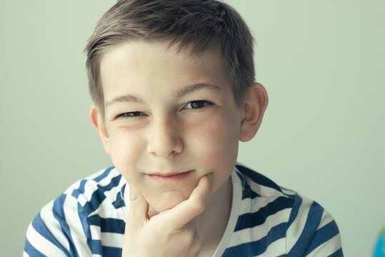 Portrait of handsome boy posing on white wall background