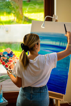 Young Woman Painting In A Canvas Taking Virtual Class