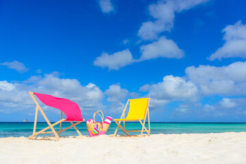 Colorful beach lounge chairs and beach bag at the beach
