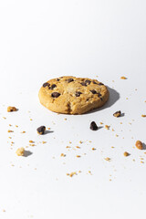Chocolate chip cookies and crumbs on white background