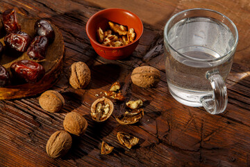 Food for iftar in holy ramadan on a wooden table dates, nuts and water.