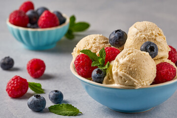 Vanilla ice cream in bowl with fresh berries . Close up