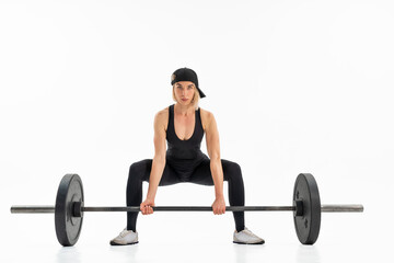 Fototapeta na wymiar Young woman doing deadlift with a barbell isolated on white