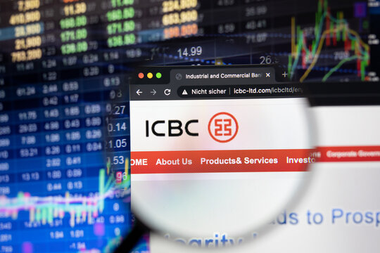 ICBC company logo on a website with blurry stock market developments in the background, seen on a computer screen through a magnifying glass