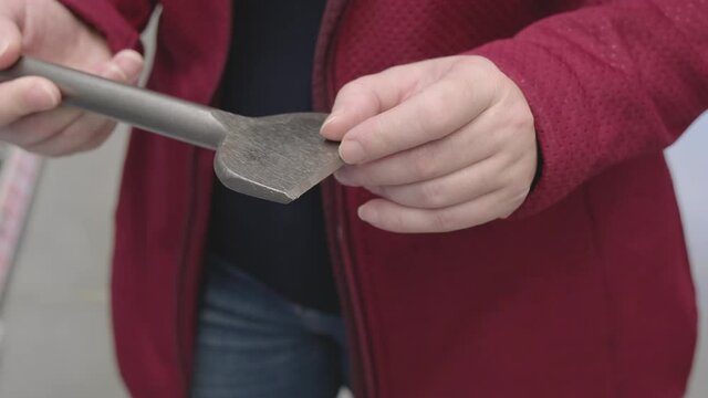 Woman in a building materials store chooses for buy a wide drill for drilling walls. Concept of women independence, feminism, gender equality, repair and construction. Close up shot
