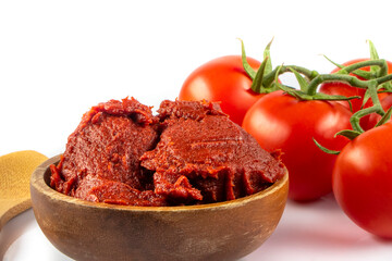 Tomatoes paste witTomatoes paste with ripe tomatoes isolated on white background. Tomatoes with a dish of tomato paste garnished. Fresh homemade tomato sauce.