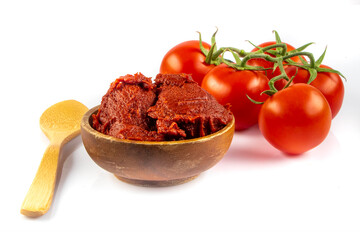 Tomatoes paste witTomatoes paste with ripe tomatoes isolated on white background. Tomatoes with a dish of tomato paste garnished. Fresh homemade tomato sauce.