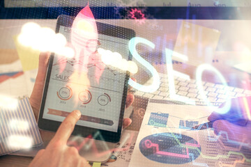 Multi exposure of man's hands holding and using a digital device and seo drawing. search...