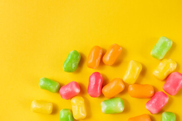 colorful candy on the yellow background. Flat lay with copy space.