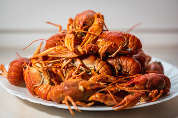 Cancer. Plate of boiled red crayfish on a light plate background. Selective focus. Delicious food concept